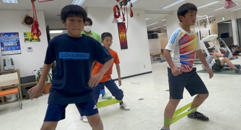 足にバンドをかけて身体を動かす子どもたち