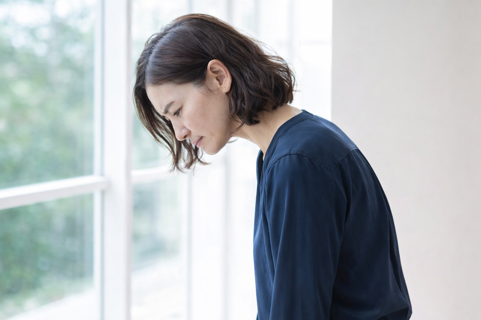 「猫背の姿勢で首が前に出て背中が丸くなっている女性」