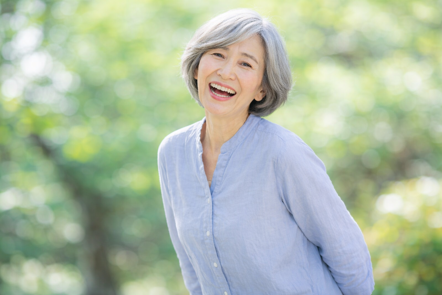 腰痛の改善後、笑顔で元気に過ごす高齢女性。圧迫骨折から回復し、快適な日常を取り戻したイメージ。 