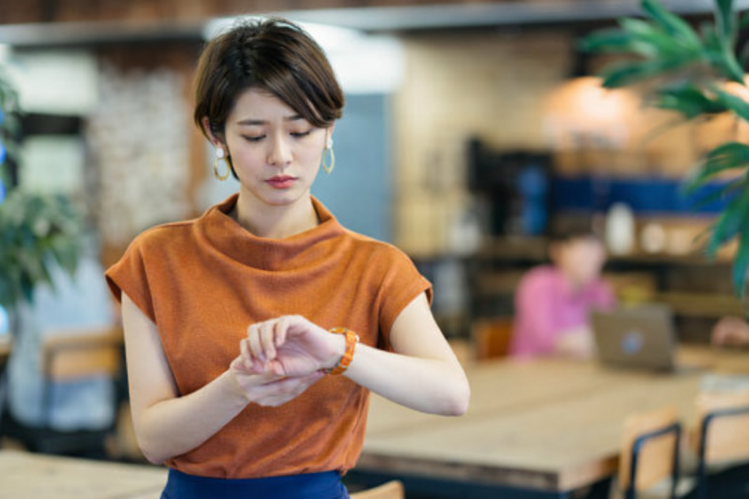 手首に違和感を覚え、不安そうに見つめる女性。手関節インピンジメントによる症状の一例。