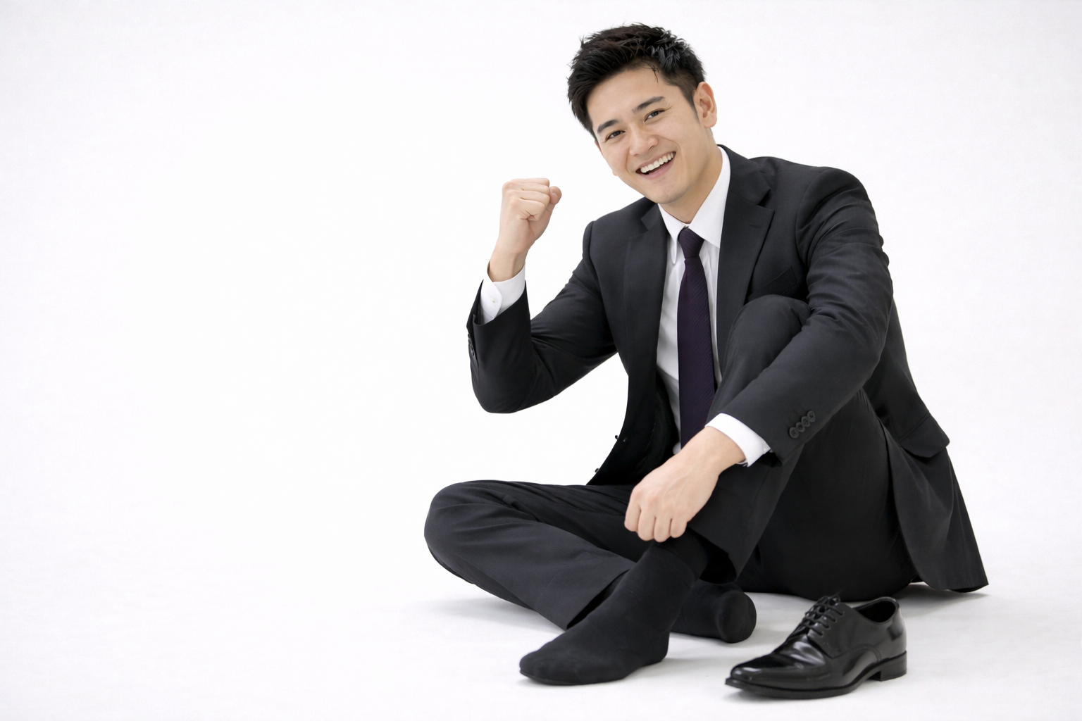 「スーツ姿の男性が笑顔でガッツポーズをしている様子。足の不調が改善されて前向きな気持ちになっているイメージ」