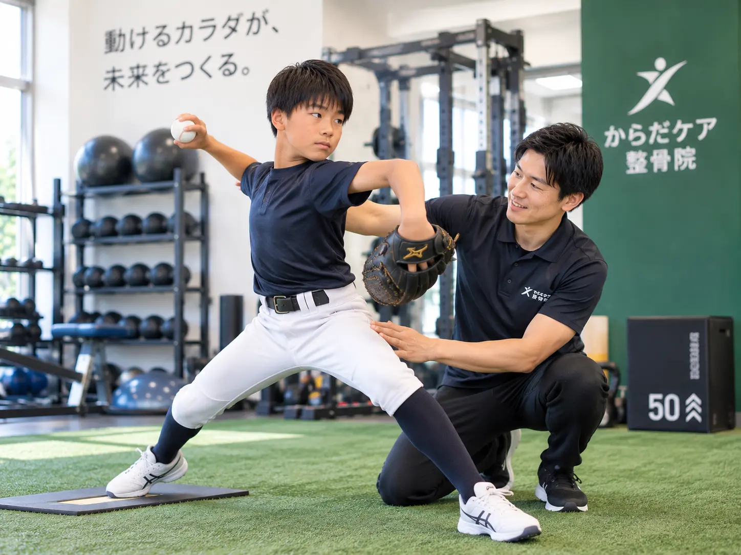 スタッフのサポートを受けながら、野球の投球フォームと身体の使い方を確認する少年のトレーニング風景。